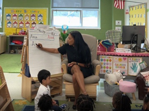 A teacher with young students learning the alphabet